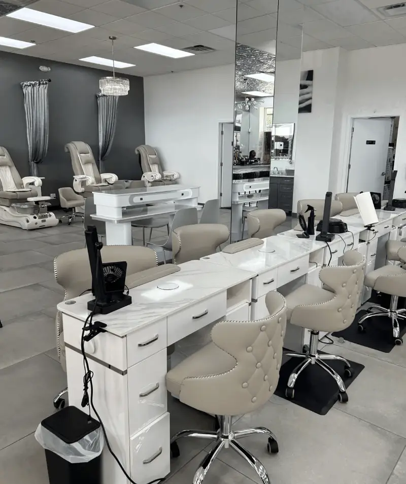 Elegant salon interior with marble manicure desks and tufted chairs